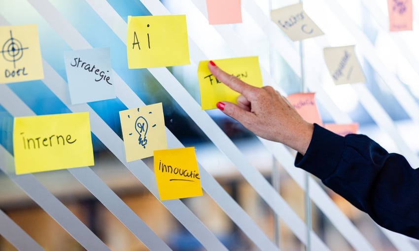 Hand van docent Lisette Kaptein wijst naar een post-it met het woord AI
